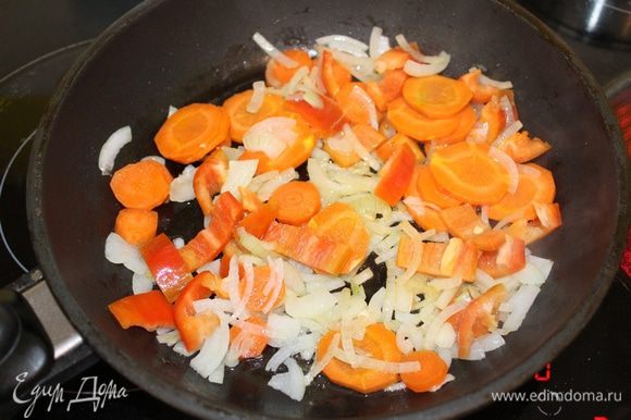 Разогреть сковороду с оливковым маслом. Обжарить лук до прозрачности 5-7 минут, помешивая. Добавить морковь, нарезанную кружочками, и перец, нарезанный кубиками. Готовить 5 минут, помешивая.