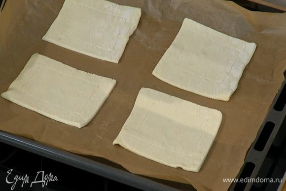 Противень выстелить бумагой для выпечки и выложить квадратики теста.