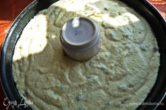 Выливаем тесто в смазанную растительным маслом тефлоновую форму 26 см в диаметре. Мне захотелось сделать отверстие в маннике,поэтому поставила в центр керамический стаканчик смазанный.