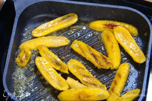 Разогреть сковороду-гриль и обжаривать половинки бананов до появления карамельных полосок, затем переложить на тарелку.
