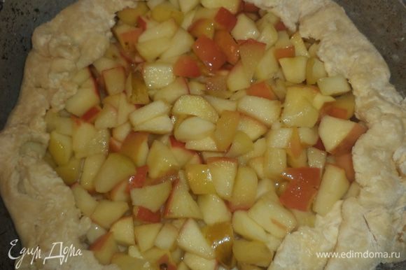 Охлаждённое тесто раскатать в круг толщиной 0,5 см. Выложить на него яблочную начинку, отступая от края на 1,5 см. Свободные края теста загнуть вверх.
