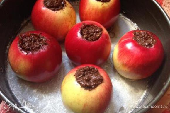 Начинить яблоки шоколадной массой, поставить в застеленную пергаментом и смазанную маслом форму.