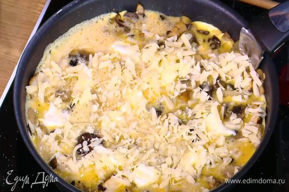 На яйца чайной ложкой выложить небольшие кусочки сливочного сыра и посыпать все натертым твердым сыром.