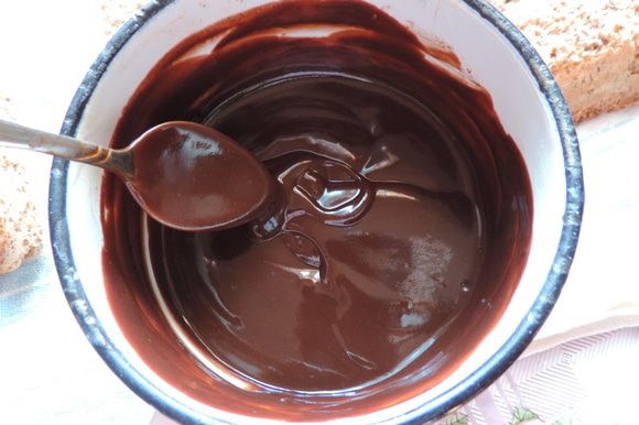 Для шоколадной прослойки (она же — ганаш) нужно нагреть сливки почти до кипения. Сливки можно взять 20%, можно более жирные — это неважно. В горячие сливки высыпаем измельченный шоколад, даем минуту постоять и перемешиваем до полной однородности.