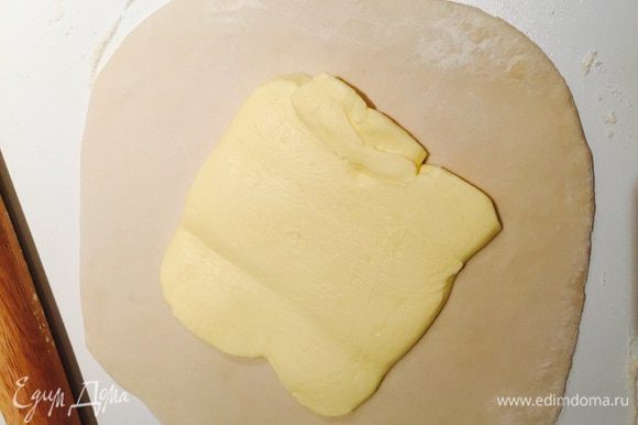 Потом раскатываем тесто в квадрат толщиной в 1 см, хорошо подпыляя мукой. В центр укладываем раскатанное в квадрат 15х15 масло.