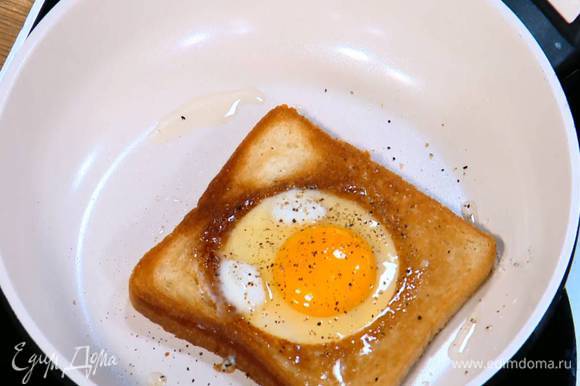 Разогреть в сковороде оливковое масло и обжаривать хлеб с одной стороны до появления золотистой корочки, затем перевернуть, разбить в вырезанные выемки по яйцу, посолить, поперчить и жарить на медленном огне до готовности яиц.