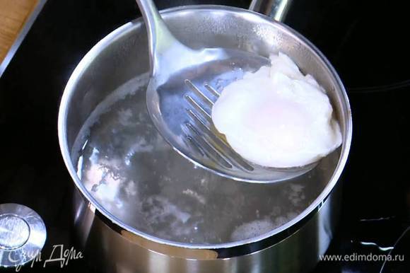 Приготовить яйца пашот: в небольшой кастрюле вскипятить воду, добавить уксус, с помощью венчика сделать маленький водоворот и в центр воронки вылить яйцо. Убавить огонь и варить 2–3 минуты, затем шумовкой выложить яйцо на тарелку. Так же приготовить второе яйцо.