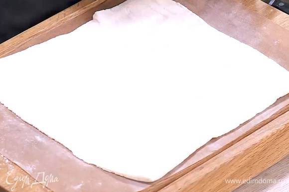 Рабочую поверхность присыпать мукой, раскатать тесто в прямоугольник и выложить на бумагу для выпечки.