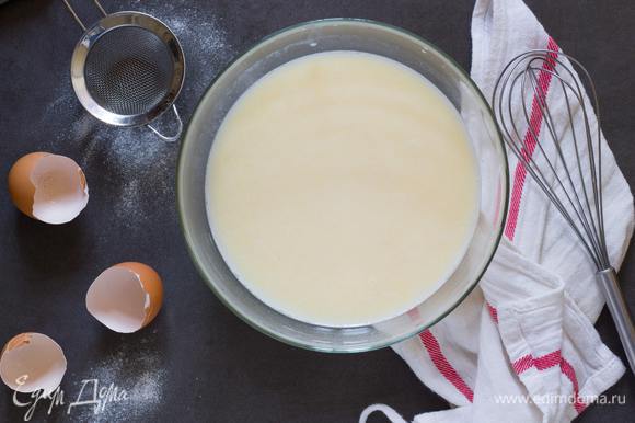 Сначала приготовьте тесто для блинов. В глубокой миске соедините молоко, кефир, минеральную воду, яйца, соль и сахар, все хорошо перемешайте, и затем добавьте теплую воду. Снова хорошенько перемешайте.