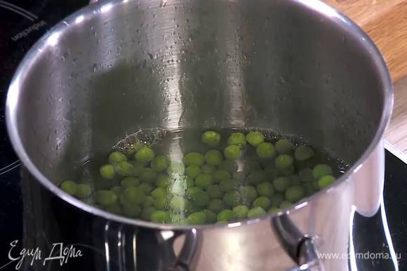 Зеленый горошек разморозить, затем опустить на пару минут в кипящую воду, затем откинуть на сито и обдать ледяной водой.