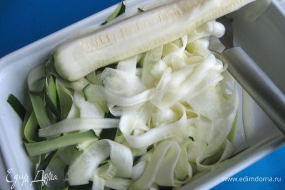 Цукини помыть, снять кожуру (кожура тоже используется) и мякоть до семечек чисткой для овощей таким образом, чтобы образовались длинные, тонкие ленточки.