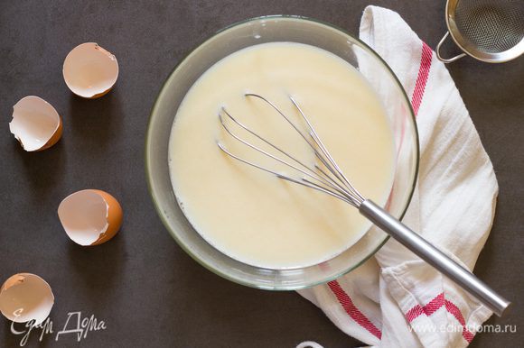 Сначала приготовьте тесто для блинов. Соедините в миске яйца, кефир, сахар, соль и теплую воду. Взбейте венчиком до однородности.