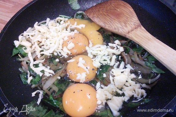 В остывший шпинат с луком разбить яйца, посолить, поперчить, добавить сыр (немного сыра оставить на посыпку), разболтать.