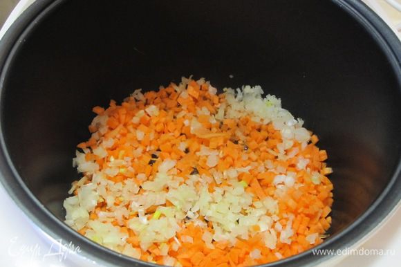 В чашу мультиварки налить 2 столовые ложки растительного масла, выложить нарезанные лук и морковь.