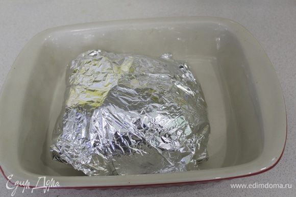 Завернуть плотно в фольгу. Запекать в предварительно разогретой до 180°C духовке 1,5 часа.