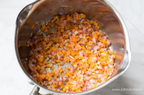 Разогрейте оливковое масло в большом сотейнике на среднем огне и обжаривайте на нем лук с морковью около 10 минут до мягкости.