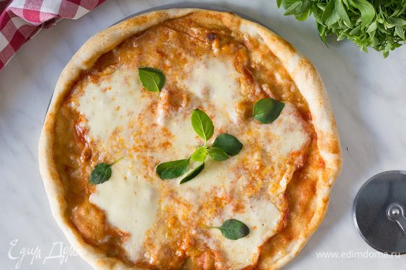 Отправьте пиццу в разогретую духовку на 6-8 минут. На готовую пиццу выложите листья базилика и подавайте. Приятного аппетита.
