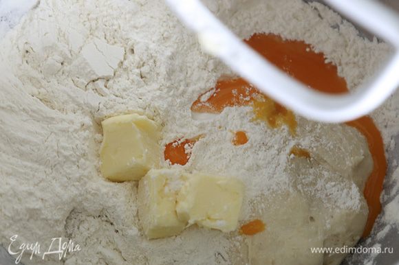 В миску с опарой добавить сливочное масло, желток, сахар, оставшуюся муку, соль, пряности. Хорошо вымесить тесто (5-6 минут в стационарном миксере).