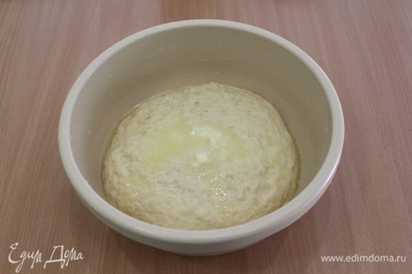 Сливочное масло растопить, слегка остудить и ввести в тесто, еще раз вымесить, подпыляйте тесто отложенной мукой.