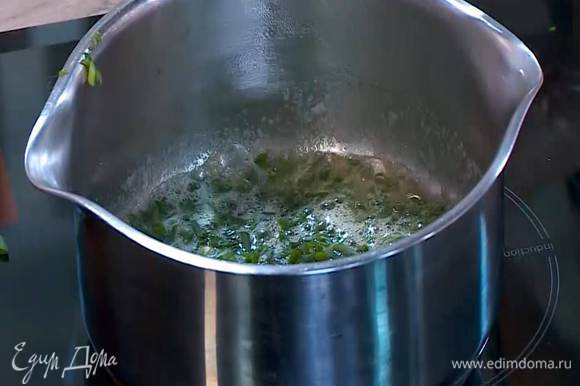 Зеленый лук мелко порезать наискосок, добавить в растопленное масло и прогревать пару минут.