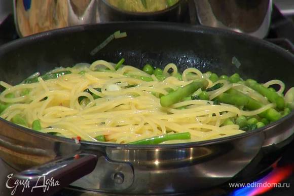 Выложить в сковороду с овощами готовые спагетти, влить немного воды, в которой они варились, затем добавить шпинат, перемешать и дать ему поплыть.