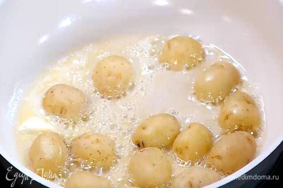 Разогреть в сковороде оливковое и сливочное масло, выложить картофель срезами вниз и обжаривать до появления золотистой корочки.