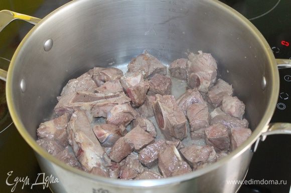 Мясо нарезать кубиками 3-4 см. В толстостенной кастрюле разогреть растительное масло и обжарить мясо со всех сторон до золотистой корочки.