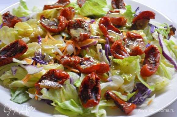 На широкую тарелку выложить салатный микс, вяленые томаты. Смешать заправку: растительное масло, горчица, сок половины лимона, соль и свежемолотый перец. Полить заправкой салатные листья и перемешать.
