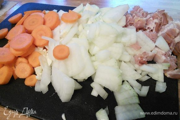 Так как жаркое в последствии будет запекаться в духовке, то удобнее готовить его в жаростойкой форме. Итак, в чугунке с толстым дном разогреть масло. Порубить лук, чеснок. Бекон мелко нарезать. Морковь — кружочками.