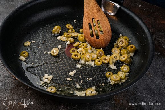Очистите чеснок, мелко порубите. Нарежьте оливки кружками и поджарьте вместе с чесноком на сковороде с оливковым маслом.