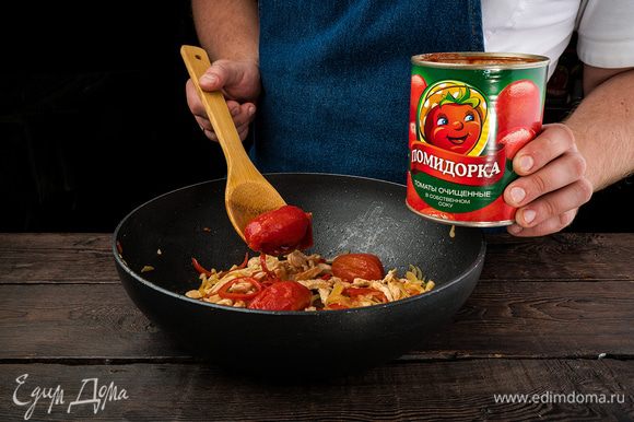 Добавляем томаты в собственном соку «Помидорка» и половину стакана воды, перемешиваем и накрываем крышкой. Отправляем на медленный огонь на 10 минут.