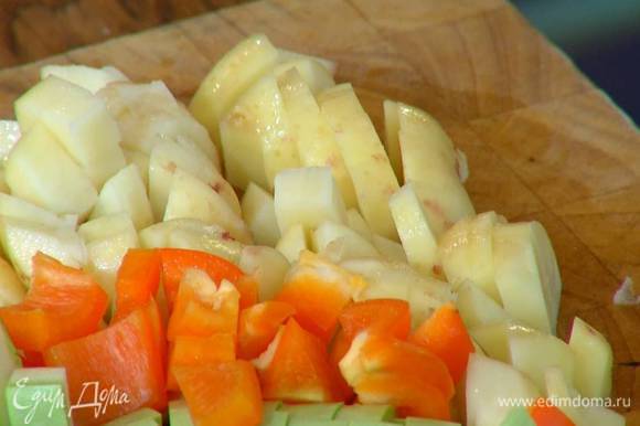 Картофель почистить, порезать маленькими кубиками, выложить в сковороду с луком и чесноком, все слегка посолить.