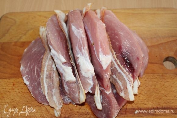 Мясо нарезать на дольки, не прорезая до конца, как книжку, в каждый разрез вложить по пластинке бекона.