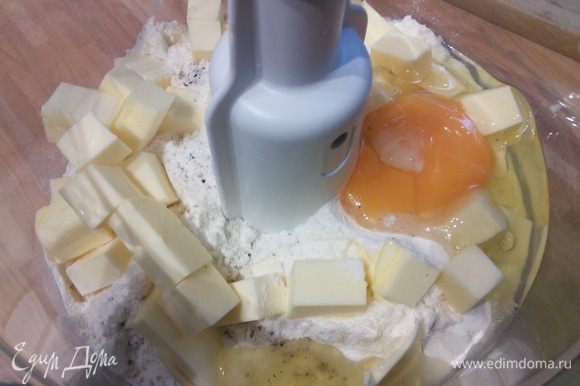 В блендере соединить муку, соль, свежемолотый перец, холодное масло, порезанное мелким кубиком и яйцо. Замесить тесто.