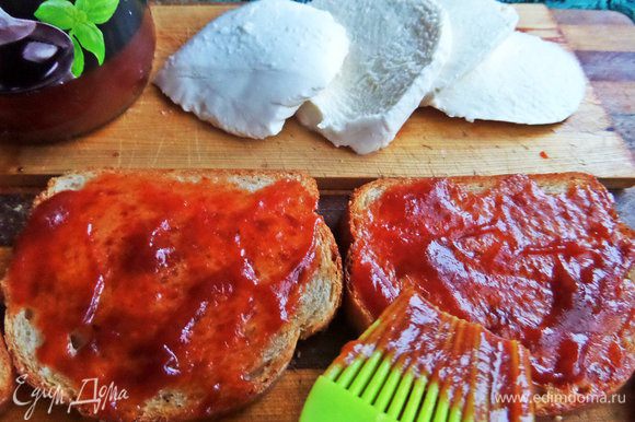 Смазать гренку томатной пастой или соусом песто.
