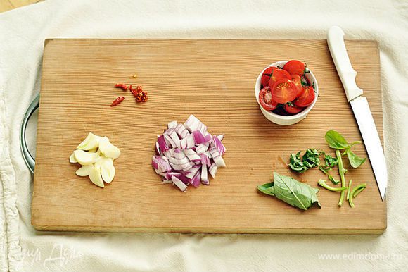Нарезать лук, листья базилика и перец чили. Чеснок нарезать на тонкие пластины, помидоры разрезать пополам.