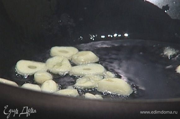 Разогреть в большой кастрюле или глубокой сковороде 1 ст. ложку оливкового масла, на небольшом огне обжарить нарезанный чеснок.