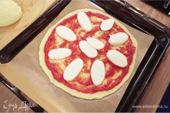 Выложить на смазанный оливковым маслом противень. Выложить приготовленное из свежих помидоров томатное пюре на тесто, сверху положить нарезанный кружочками свежий сыр моцарелла (или натереть моцареллу для пиццы на терке).
