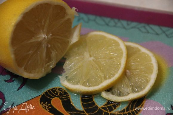 Тем временем нарежем пару долек лимона и тоже добавим в напиток. Оставим настой на 15 минут.