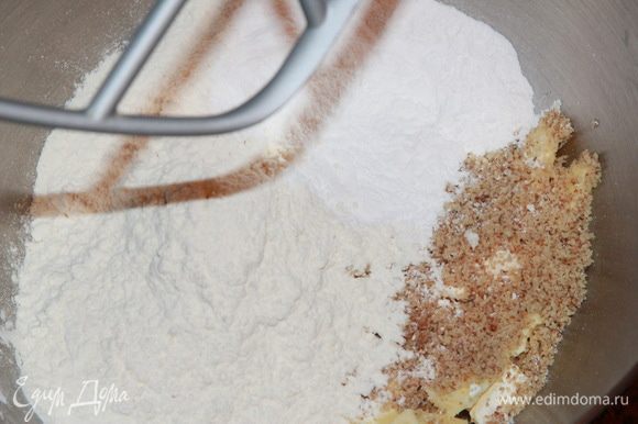Сначала приготовим основу из теста сабле, на которой будет стоять наш торт. Для этого в чашу комбайна кладем нарезанное кубиком масло, затем добавляем молотые в очень мелкую крошку орехи, соль, сахарную пудру и муку.