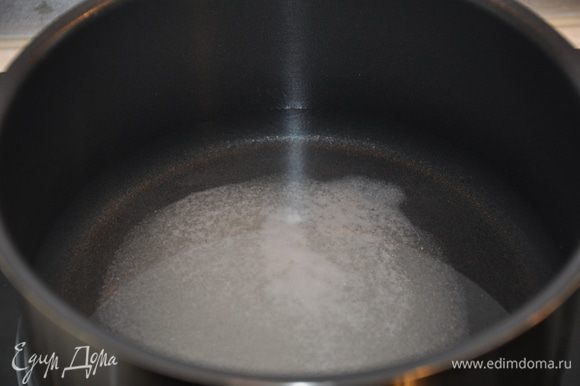 В первую очередь необходимо замариновать лук. Для этого налейте в кастрюлю стакан воды, добавьте 3 столовые ложки сахара и половину столовой ложки соли.