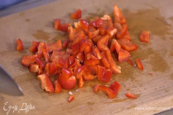 Сладкий перец, удалив плодоножку и семена, нарезать небольшими кусочками, выложить к луку и обжарить.