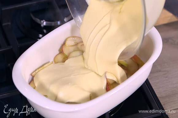 В жаропрочную керамическую форму выложить яблоки вместе с соусом и залить тестом.