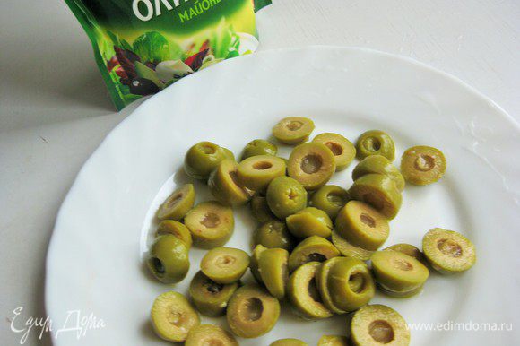 Порезать оливки кружочками.