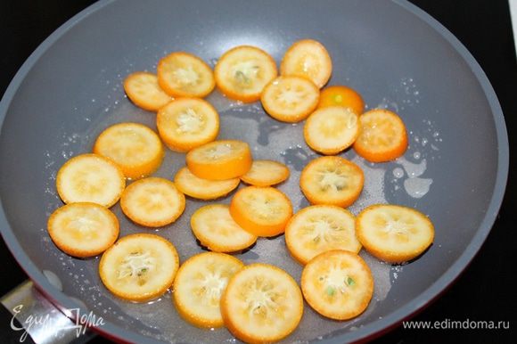 Выжать сок из апельсина, смешайте с сахаром и перелейте смесь в сковородку. Доведите до кипения. Кумкваты нарежьте на дольки, и выложите в кипящий сироп. Проварите 2 — 3 мин.