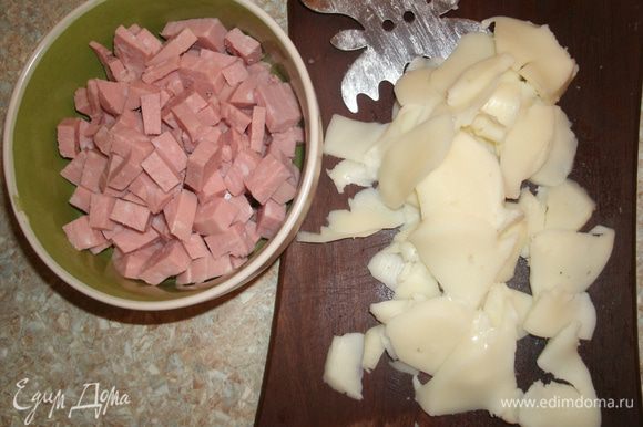 Вареную колбасу нарезать мелкими кубиками, сыр — пластинками (лучше сделать это сырорезкой).