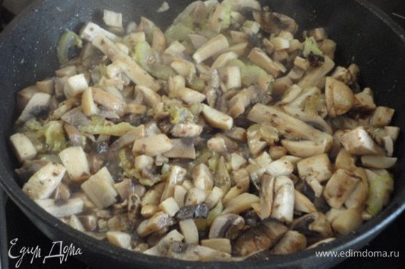 На сковороде разогреть растительное масло и обжарить до мягкости сельдерей, затем добавить мелко нарезанные шампиньоны. Тушить на медленном огне, давая возможность испариться влаге.