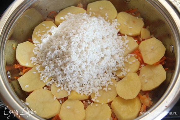 На картофель выложить слой промытого риса.
