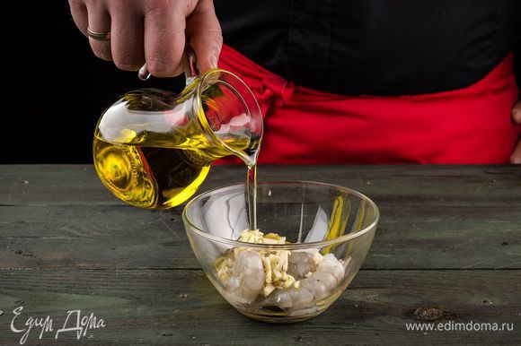 Чтобы замариновать креветки, мелко рубим чеснок, добавляем 2 ст. л. оливкового масла и перемешиваем с креветками. Оставляем мариноваться минут на 20.