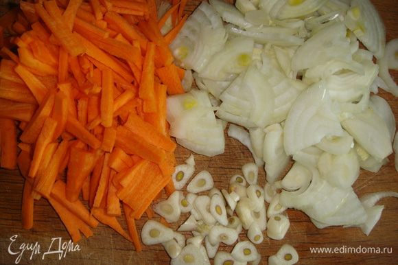 Овощи почистить. Морковь нарезать тонкой соломкой, лук — сначала полукольцами, затем — полукольца пополам, чеснок — пластинками.